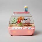Toy aquarium with fish and a small character on top, set against a dark background.