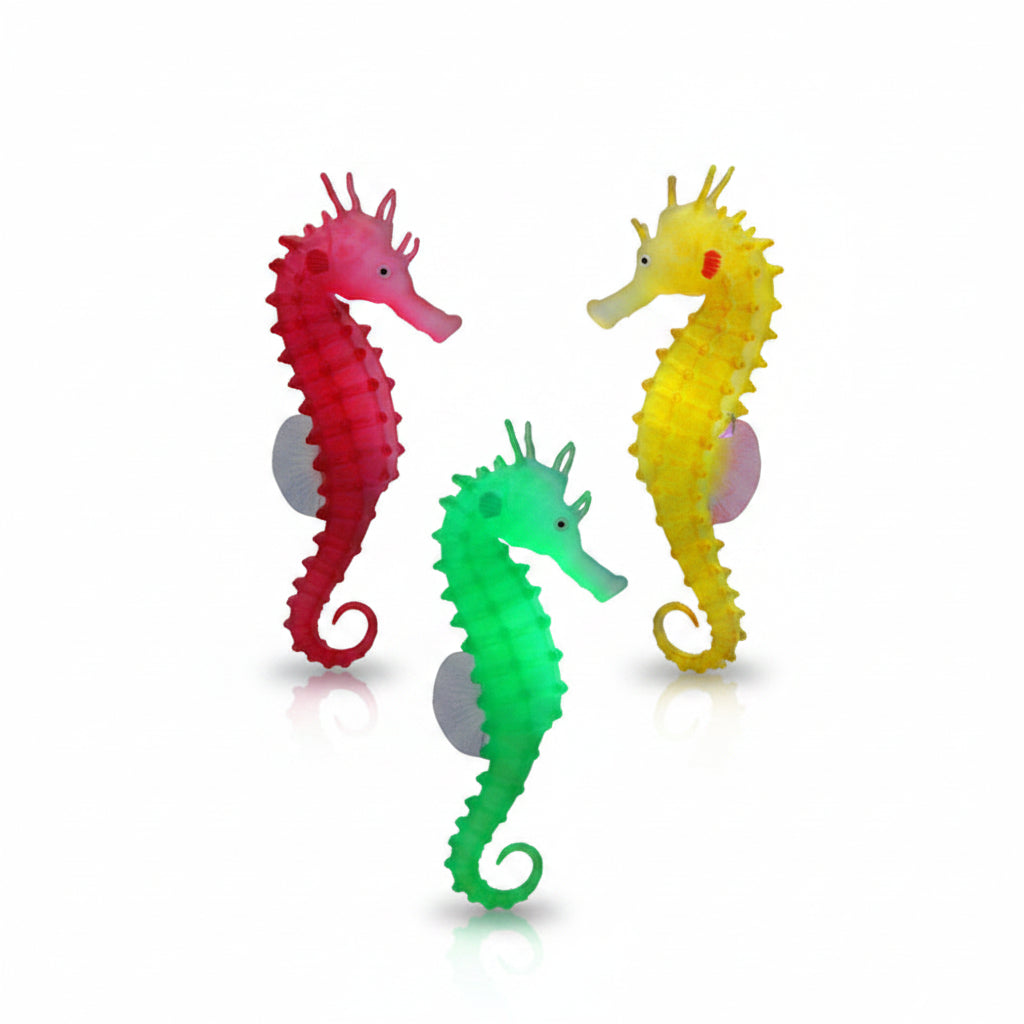 Three colorful seahorses on a dark background with green plants.