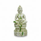 Stone Buddha statue in a natural setting with rocks and plants